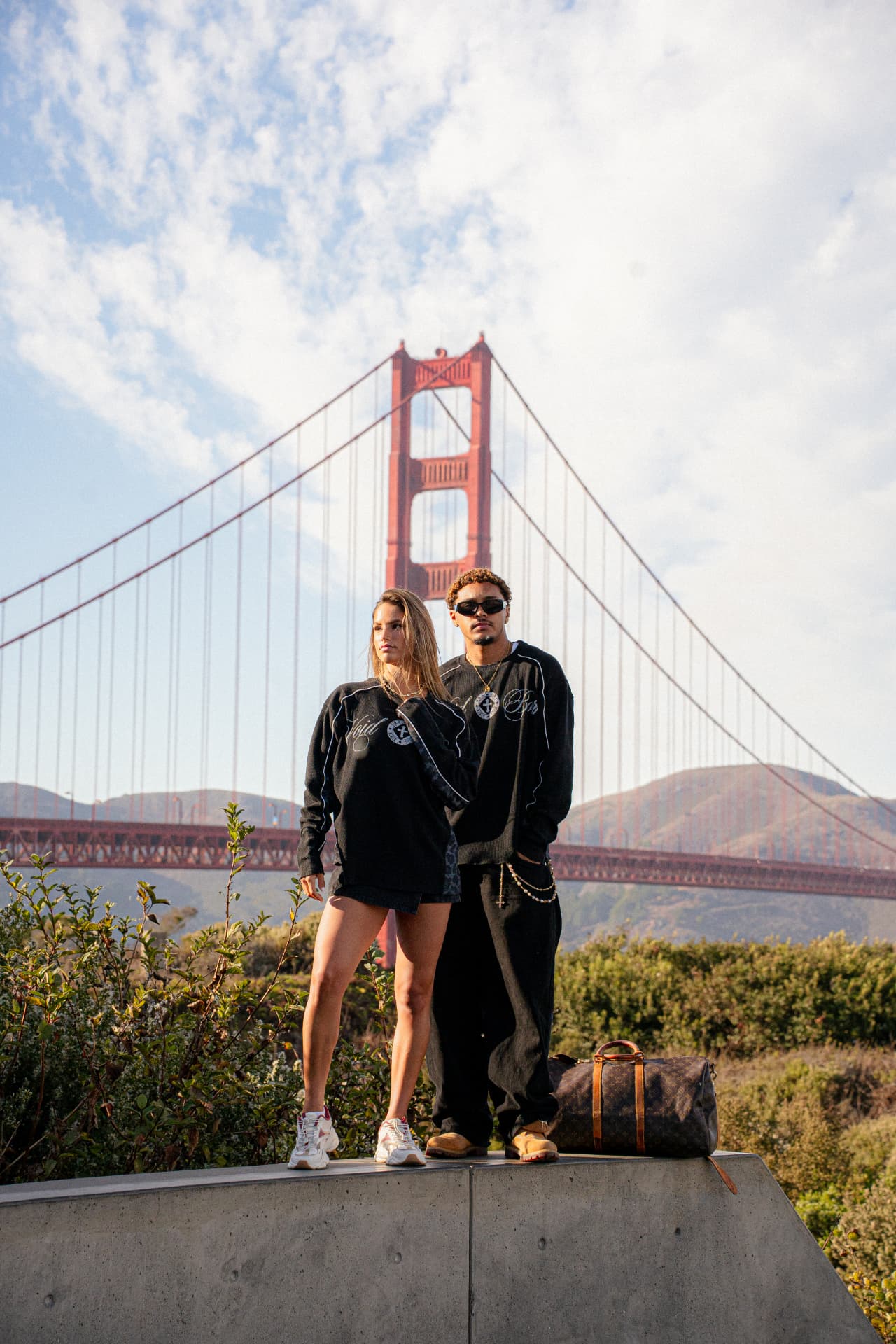 Voidborn black sweatshirt styled with dark shorts beside the Golden Gate Bridge