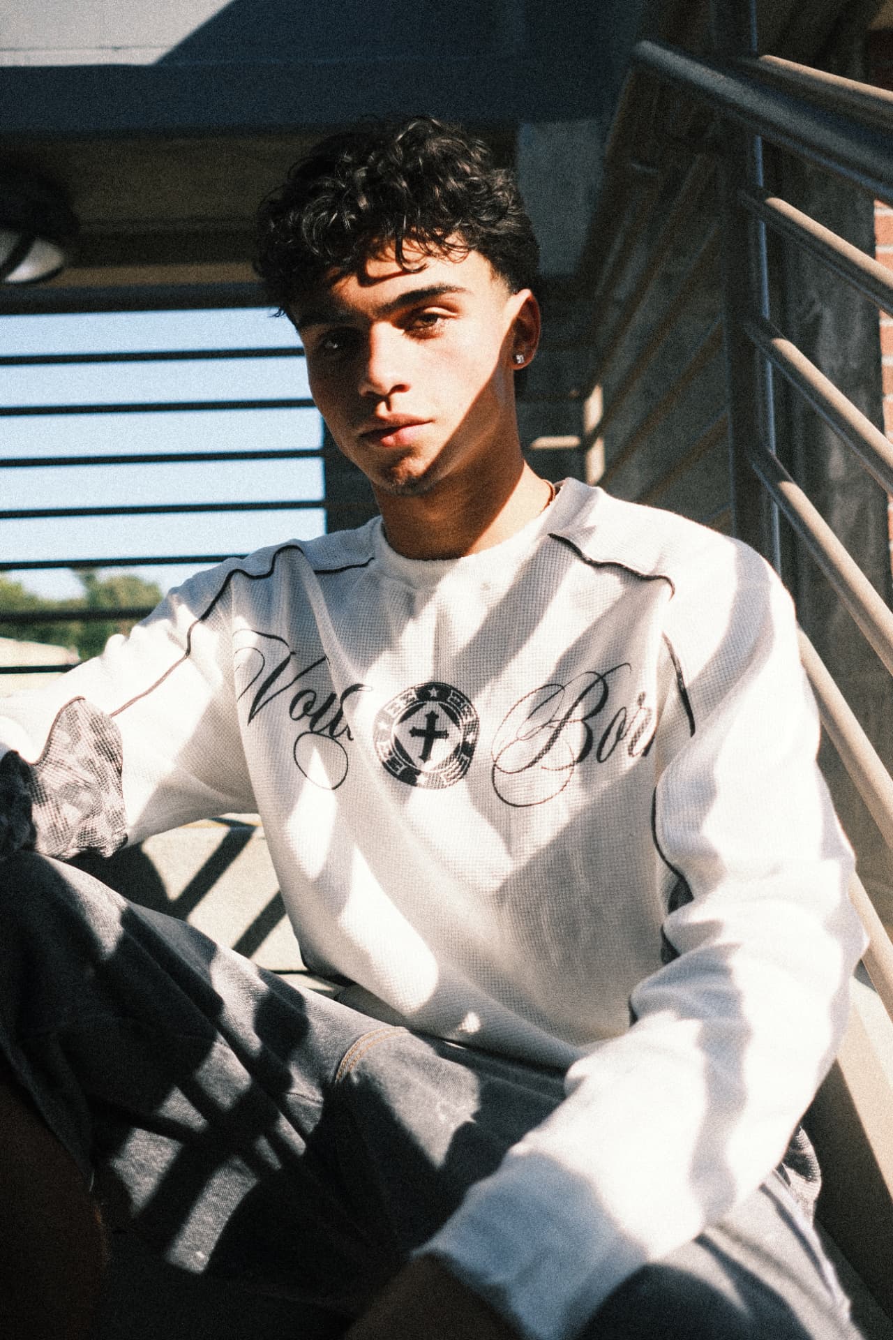 Voidborn white thermal worn on a sunlit stairway