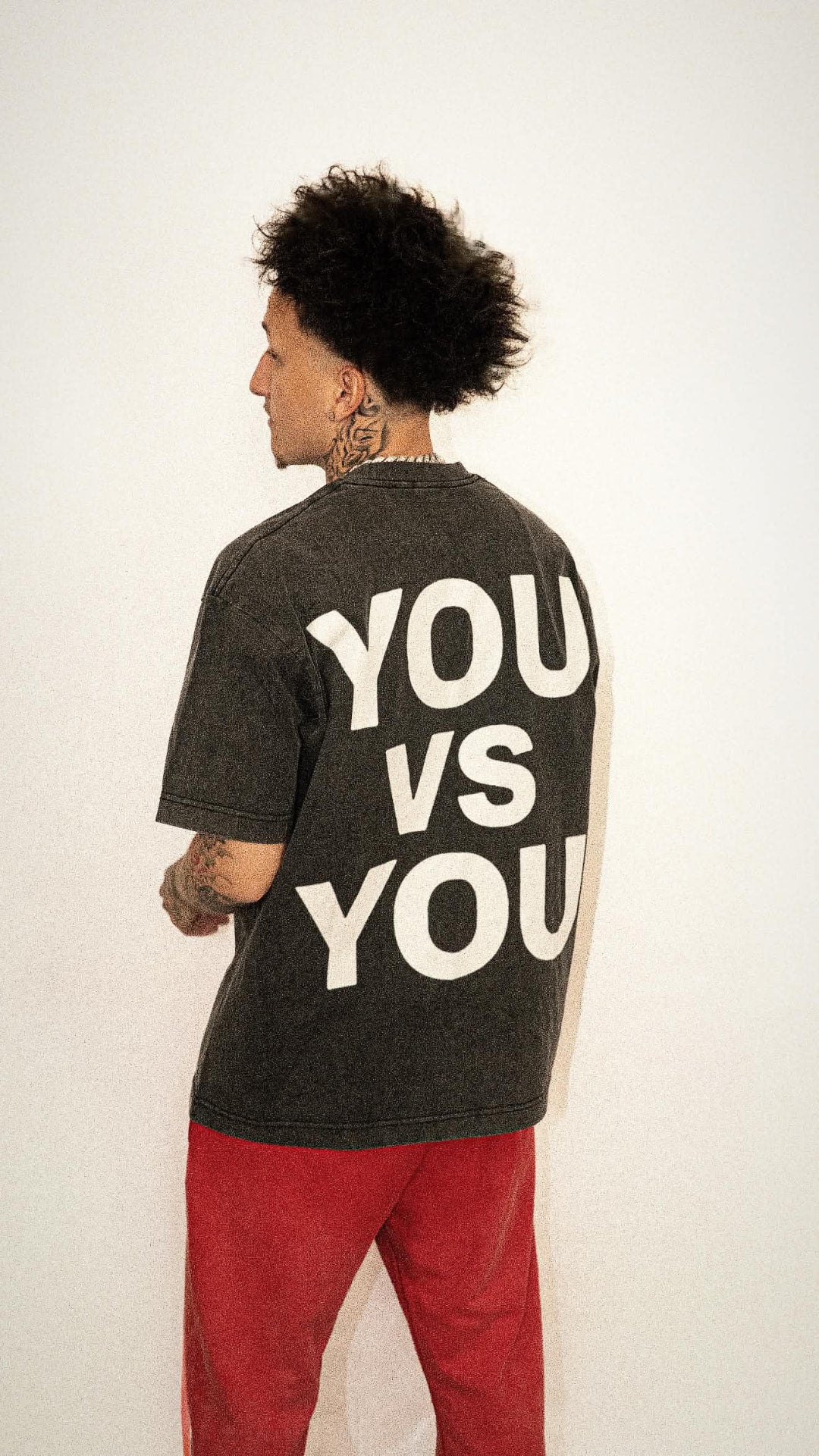 Voidborn charcoal tee with white You Vs You back print and red trousers